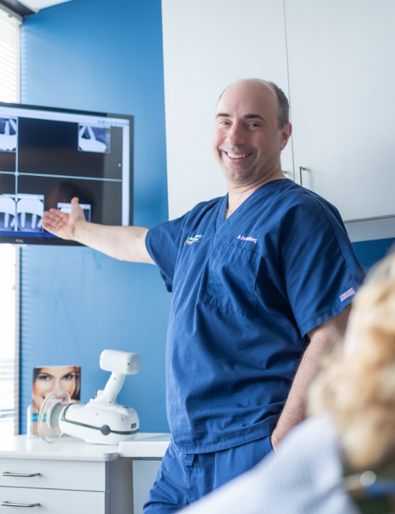 Dentist showing a patient x rays of their mouth with dental implants