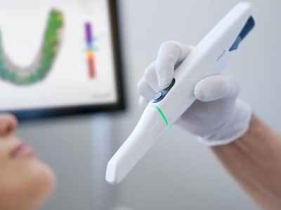 Dentist holding a wand like device for taking digital dental impressions