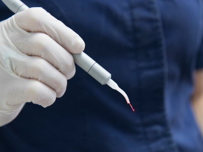 Dentist holding a metal pen like dental laser