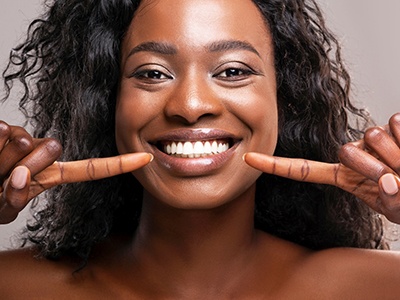 Young female pointing to her beautiful smile