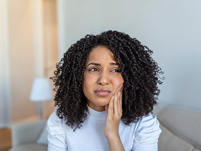 Woman experiencing toothache at home