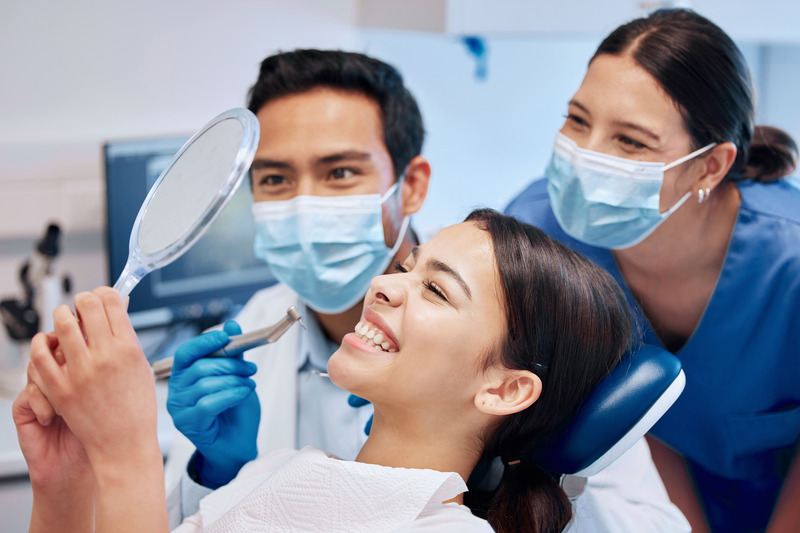Patient smiling in mirror after cosmetic dentistry